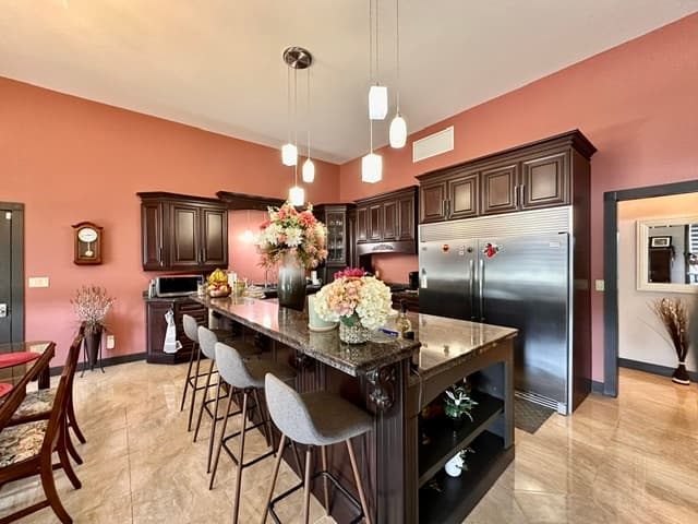 Large kitchen with island seating and warm cabinetry